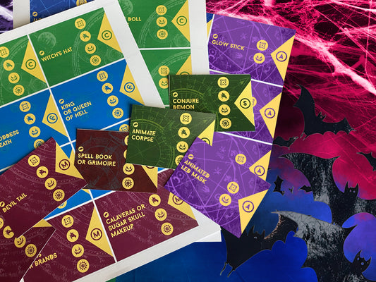 Halloween-themed playing cards with colorful designs on a dark background with spider webs and bats.