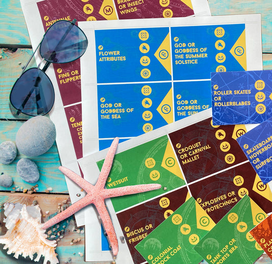 Colorful character generator game cards with various activities and objects on a wooden surface with sunglasses and seashells.