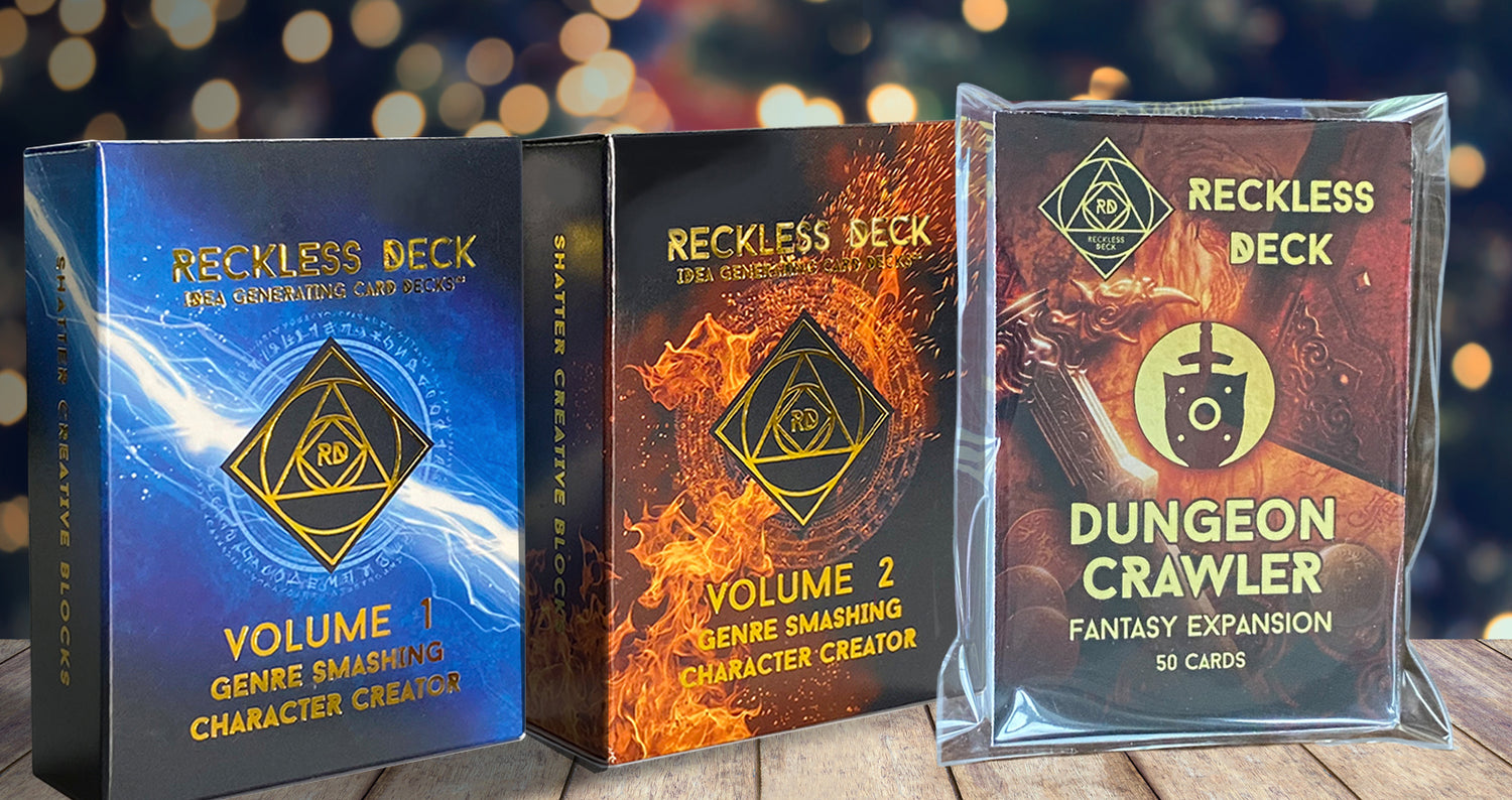 Three 'Reckless Deck' game expansions on a wooden surface with a blurred Christmas tree in the background.